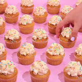 Vegan Vanilla Cupcakes with plant-based icing and rainbow sprinkles, freshly baked and ready to enjoy from Crumbs & Doilies.